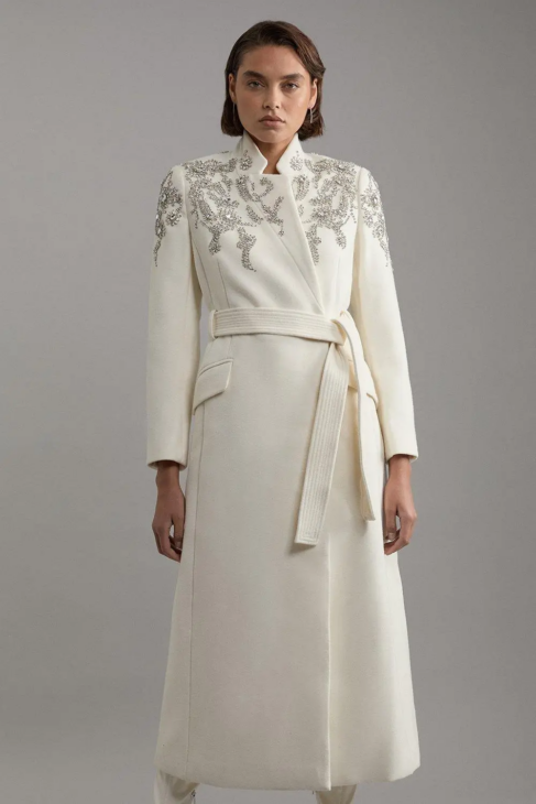 Belted winter white coat with refined detailing for elegant cold weather styling