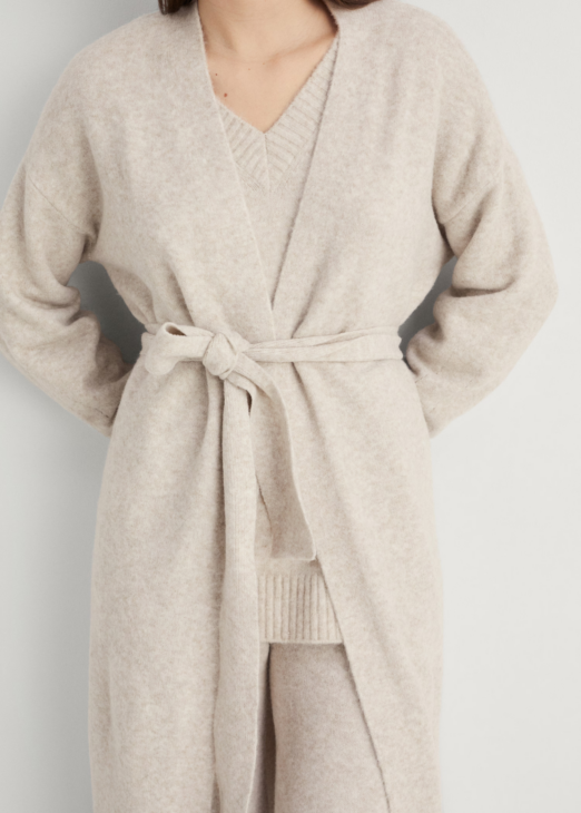 Long knitted cardigan styled over winter white layers
