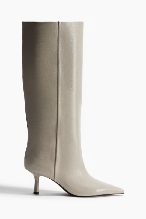 Knee-high boots styled with an ivory coat winter outfit

