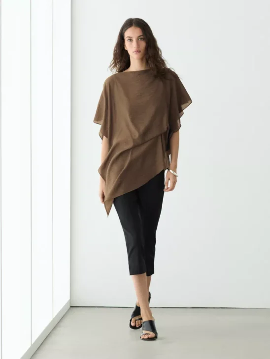 Asymmetric cape style layer adding movement to a modest outfit